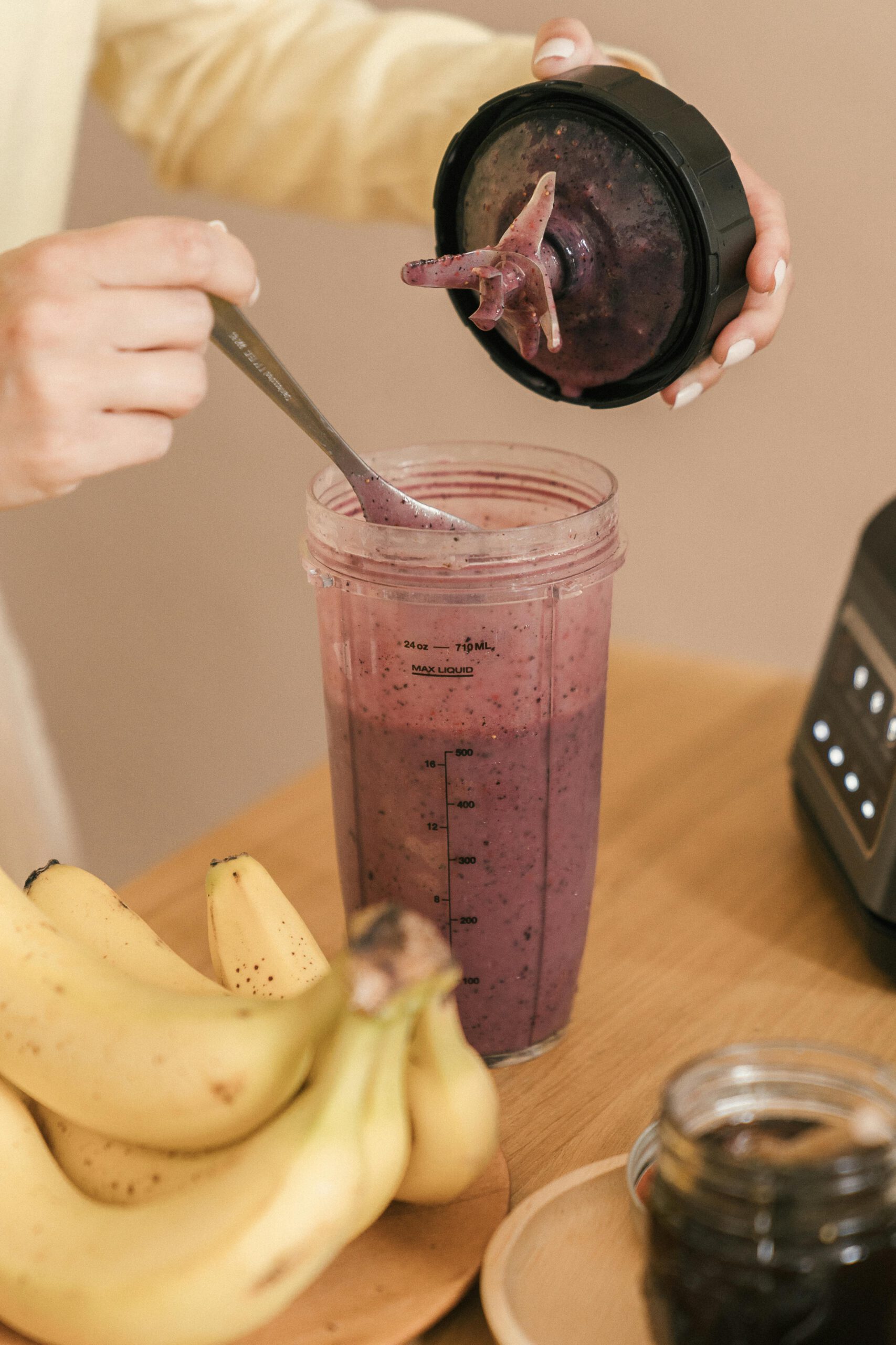 Close-up of a homemade smoothie preparation with bananas and mixed berries.